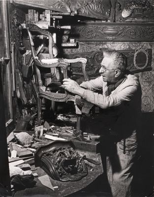 black and white photo of a man working on a piece of wood