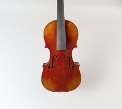 un vieux violon posé sur une surface blanche, avec un fond blanc