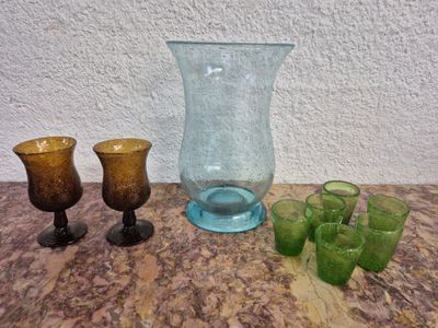 plusieurs vases et verres en verre de différentes couleurs posés sur une table