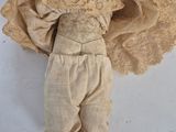 an old doll is laying on a white surface with a hat on