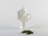 a white fire hydrant with a leaf on the ground