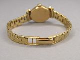 a close up of a gold wrist watch on a white surface