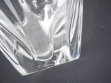 a clear glass vase with a black base on a table