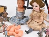 a lot of dolls sitting on the floor next to a chair
