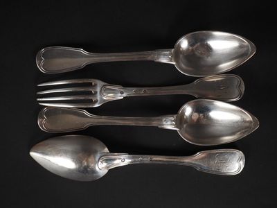 quatre cuillères en argent et deux cuillères en argent posées sur une surface noire