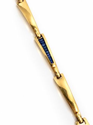 une image représentant un bracelet en or orné d'une pierre bleue au centre