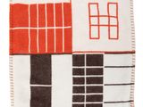 un gros plan d'un tapis rouge et blanc posé sur une surface blanche
