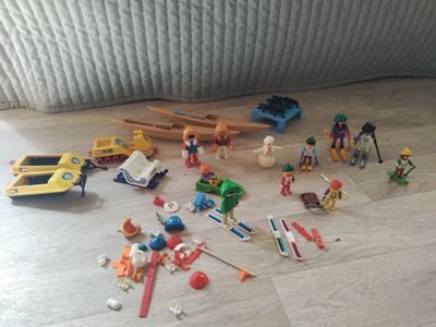 un tas de jouets par terre, à côté d'un lit