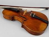 a violin that is sitting on a white surface