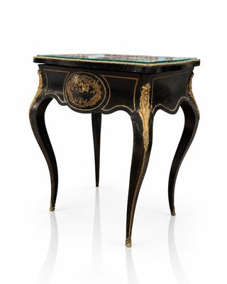 a black and gold table with a glass top on a white surface