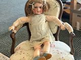a doll that is sitting on a chair in a room