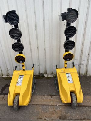 two yellow traffic lights sitting next to each other on the side of a building