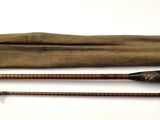 two old fishing rods and a bag on a white surface