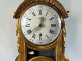 a gold clock with roman numerals on the face