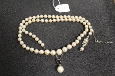 gros plan d'un collier de perles sur une surface noire