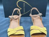 une paire de sandales jaunes posée sur une table bleue