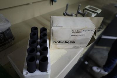 a box of black bottles sitting on a counter next to a box of black bottles