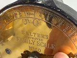 a hand that is holding a clock that is on a table