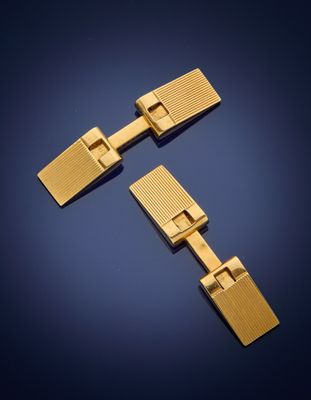a pair of gold cufflinks on a blue background