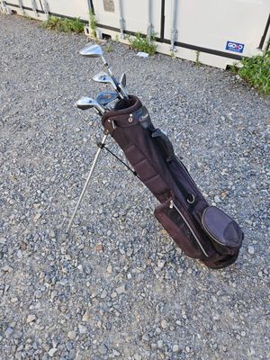un sac de clubs de golf posé par terre près d'un mur