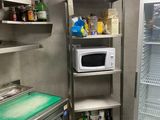 a refrigerator and a microwave in a small kitchen