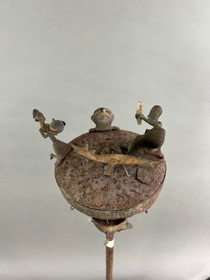 une statue représentant une grenouille assise au sommet d'une horloge