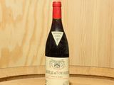 une bouteille de vin posée sur un tonneau en bois