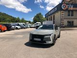 une voiture blanche garée devant un immeuble devant lequel sont garées d'autres voitures