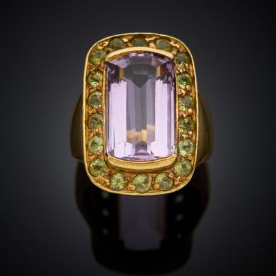 a gold ring with an amethorate and peridots
