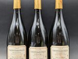 trois bouteilles de vin posées sur une table l'une à côté de l'autre