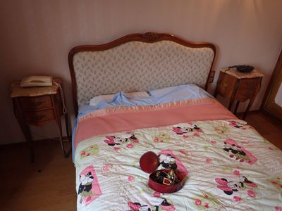 un lit recouvert d'une couette rose et blanche