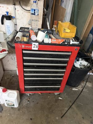 a red tool box with tools on it in a garage