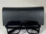 une paire de lunettes noires posée sur un étui noir