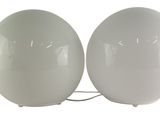 two white eggs sitting next to each other on a white surface