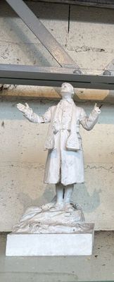 une statue représentant un homme debout sur une table