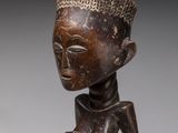 a close up of a statue of a person with a hat on