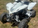 an image of a white four wheeler atv parked in the grass