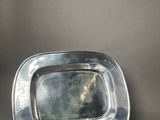 a silver plate with a mirror on it on a table