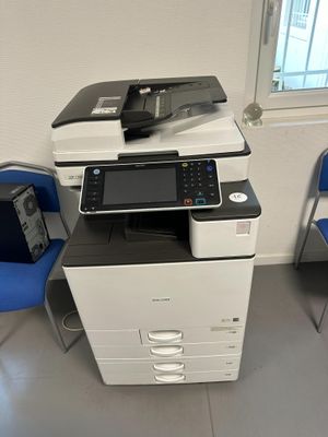 une imprimante multifonction posée sur une chaise dans une pièce