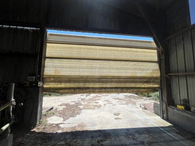 une grande porte de garage ouverte, équipée d'un store à enrouleur