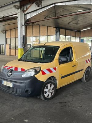 une petite camionnette jaune garée dans un parking couvert