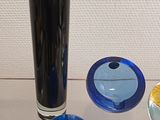 a glass vase sitting on top of a table next to other glass objects