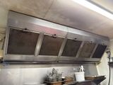a large stainless steel kitchen with a range hood