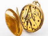 a gold pocket watch with a gold coin inside it