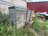 an old wooden box sitting in the grass next to a building