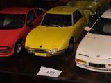 Plusieurs petites voitures sont exposées dans une vitrine.