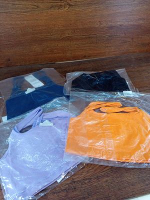 un tas de vêtements posé sur une table, avec des sacs en plastique
