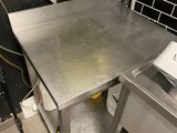 a stainless steel table in a kitchen with a hose attached to it
