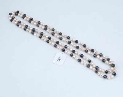 un gros plan d'un collier composé de perles blanches et noires posé sur une surface blanche