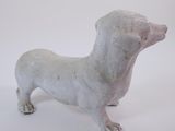 a small statue of a dachshund on a white background